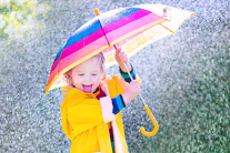 Lachendes Kind mit Regenschirm