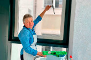 Frau bei Fensterputzen