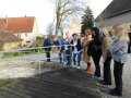 Personen stehen vor Winterbecken für Karpfen