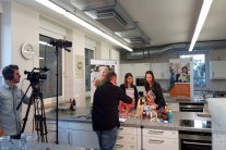 Zwei Frauen unterhalten sich in der Schulküche und werden dabei vom Kamerateam gefilmt
