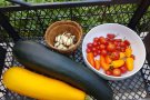 Kiste mit Zucchini, Knoblauch, Cocktailtomaten und Paprika bunt