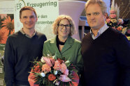 Dame mit Blumenstrauß steht zwischen zwei Referenten