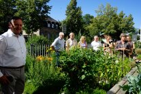 Personen stehen in einem Garten