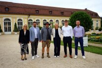 6 Personen stehen im Freien nebeneinander