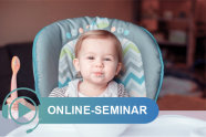 Kind sitzt in Hochstuhl und hält Löffel in seiner rechten Hand; Schriftzug Online-Seminar